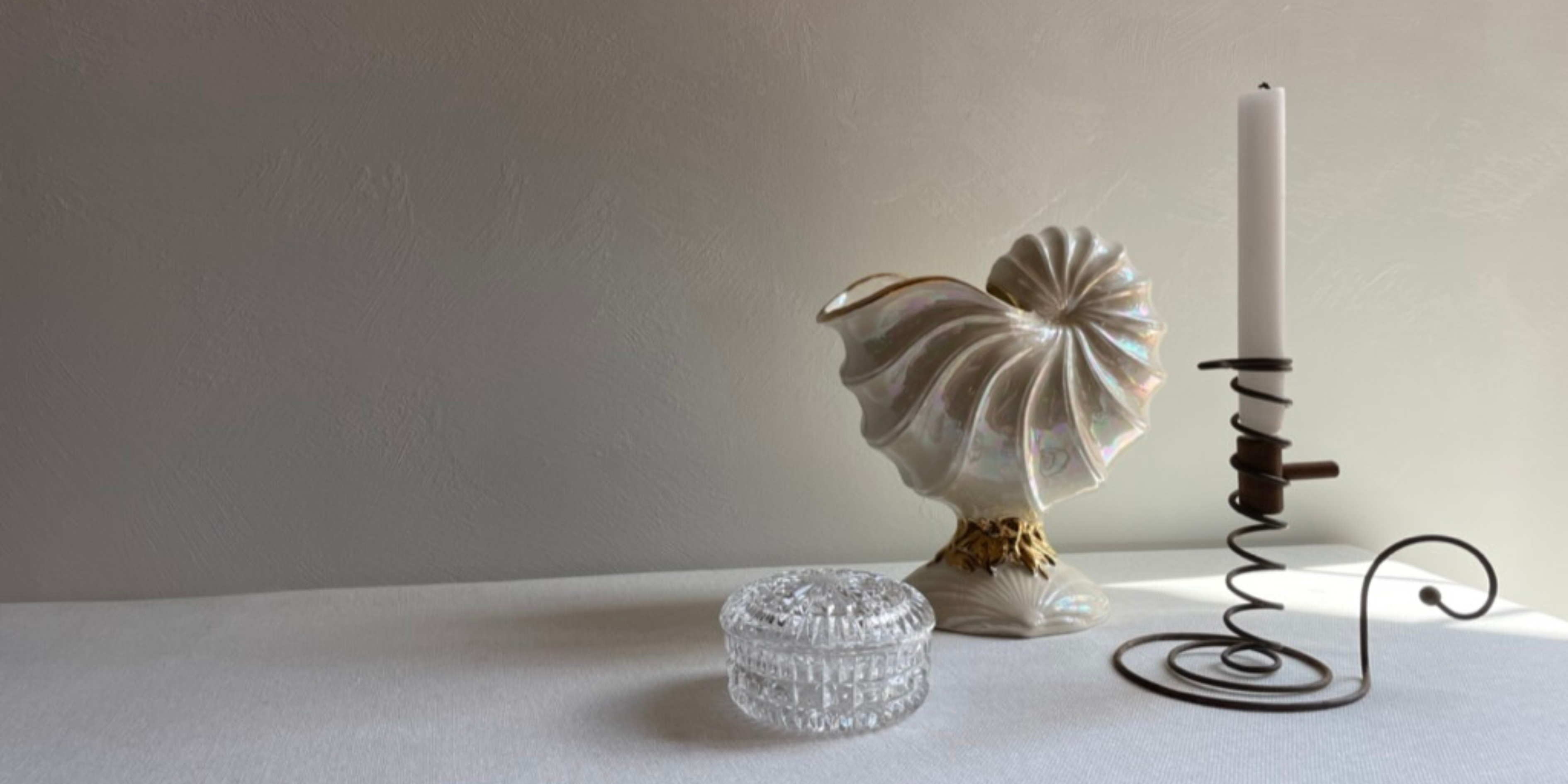 Vintage vase and candle stick displayed on linen tablecloth