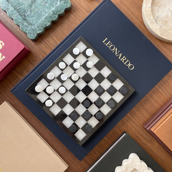 stone checkers game displayed on coffee table book