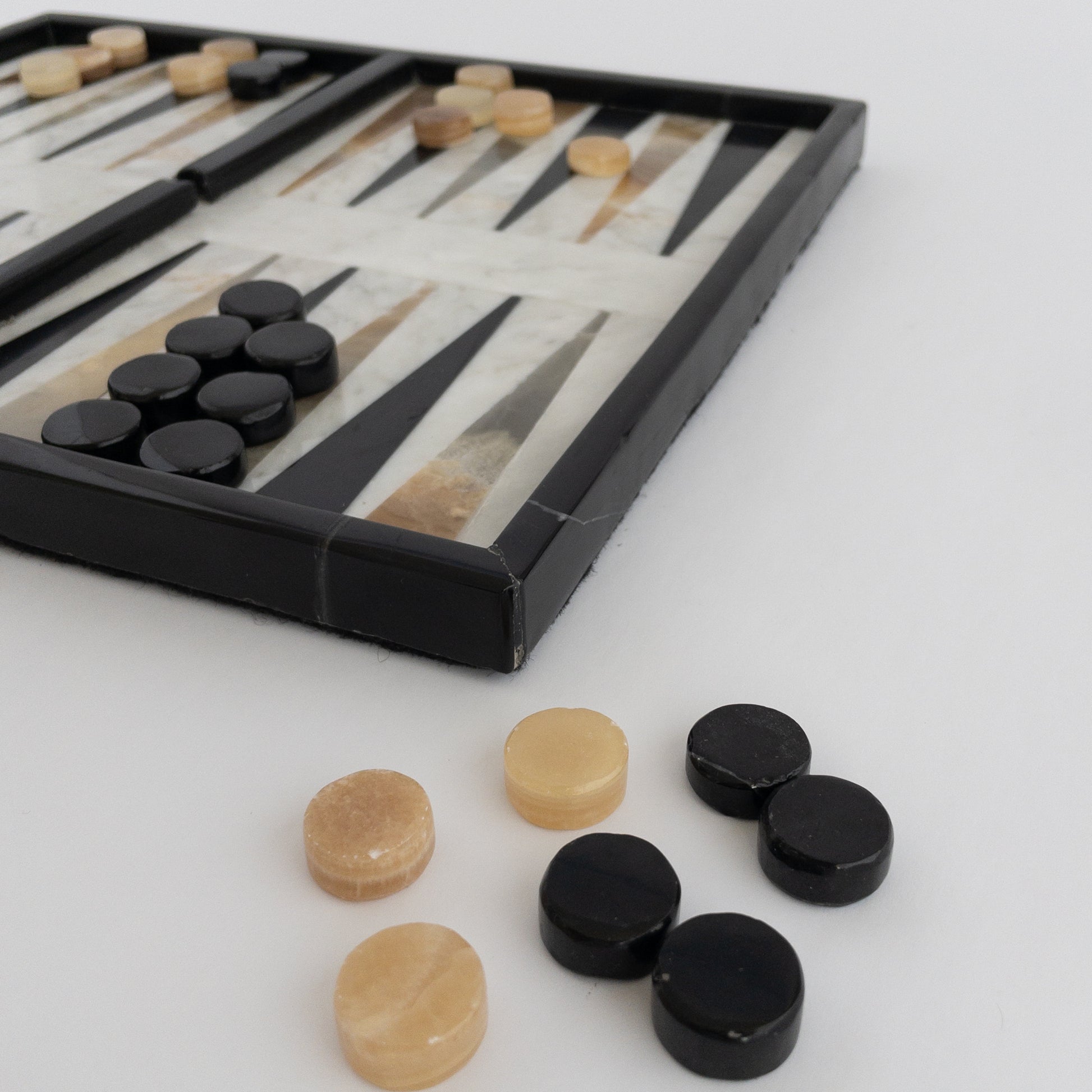 close-up of natural stone backgammon playing pieces in brown onyx