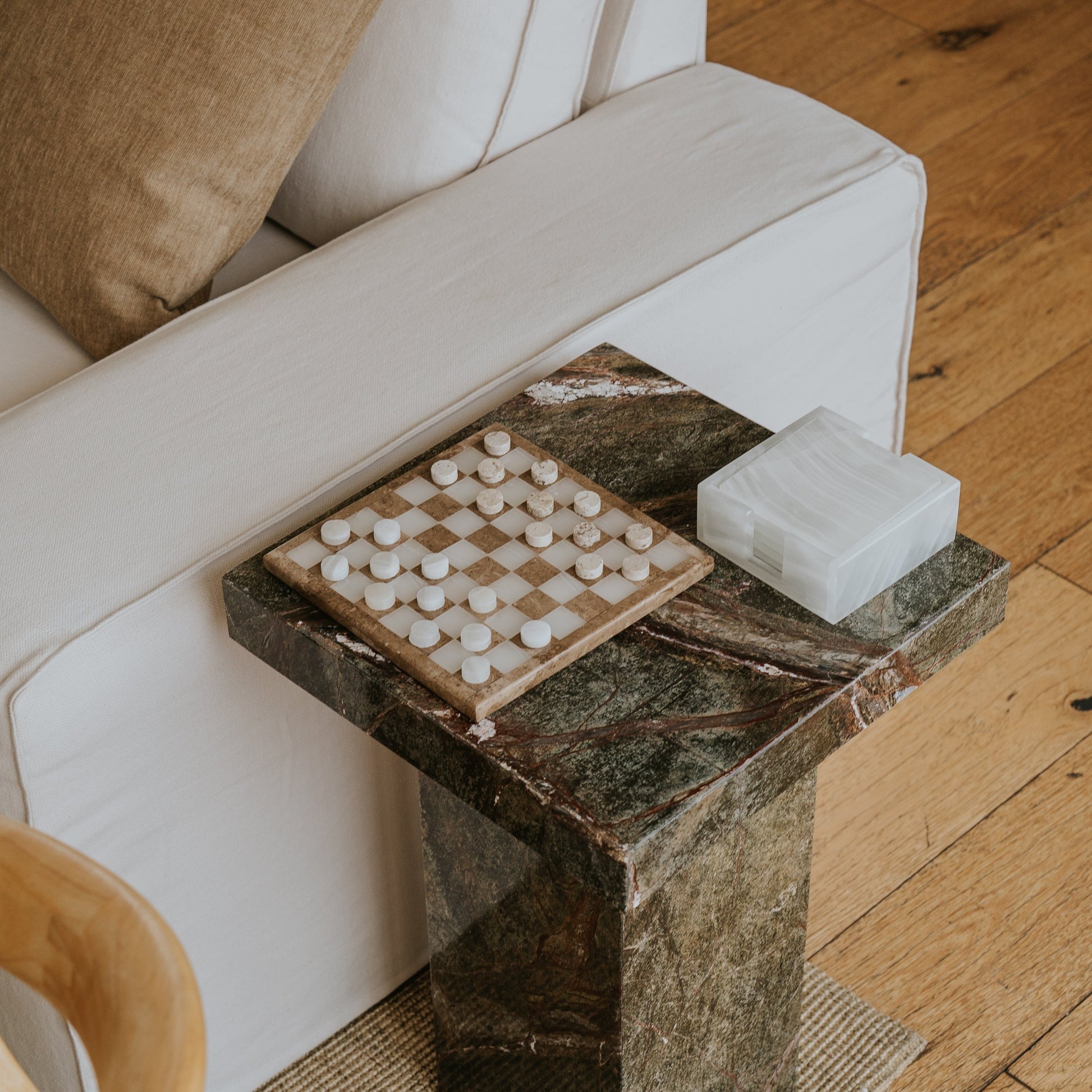 stone coasters on green marble table next to stone checkers