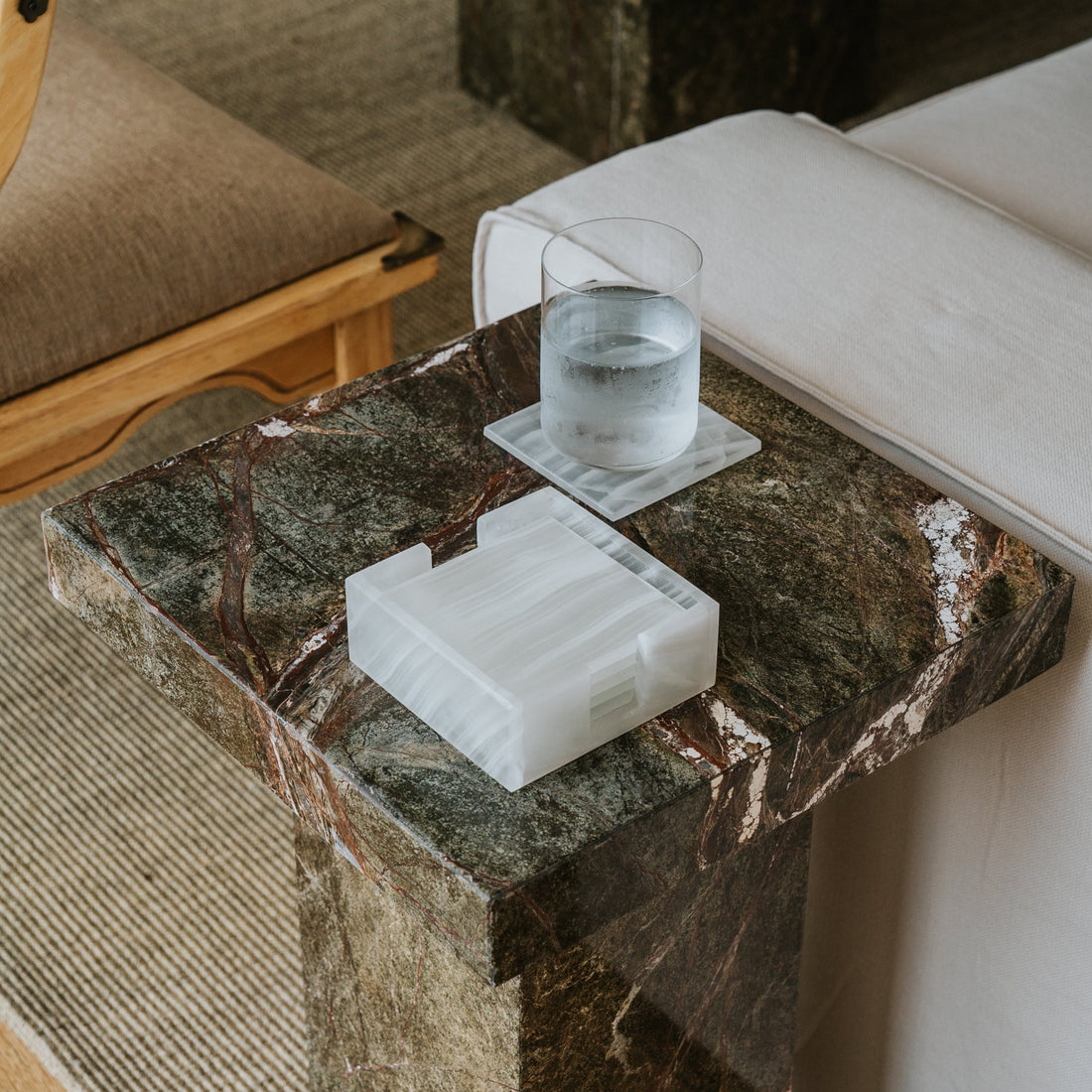 natural stone coasters on side table with glass of water