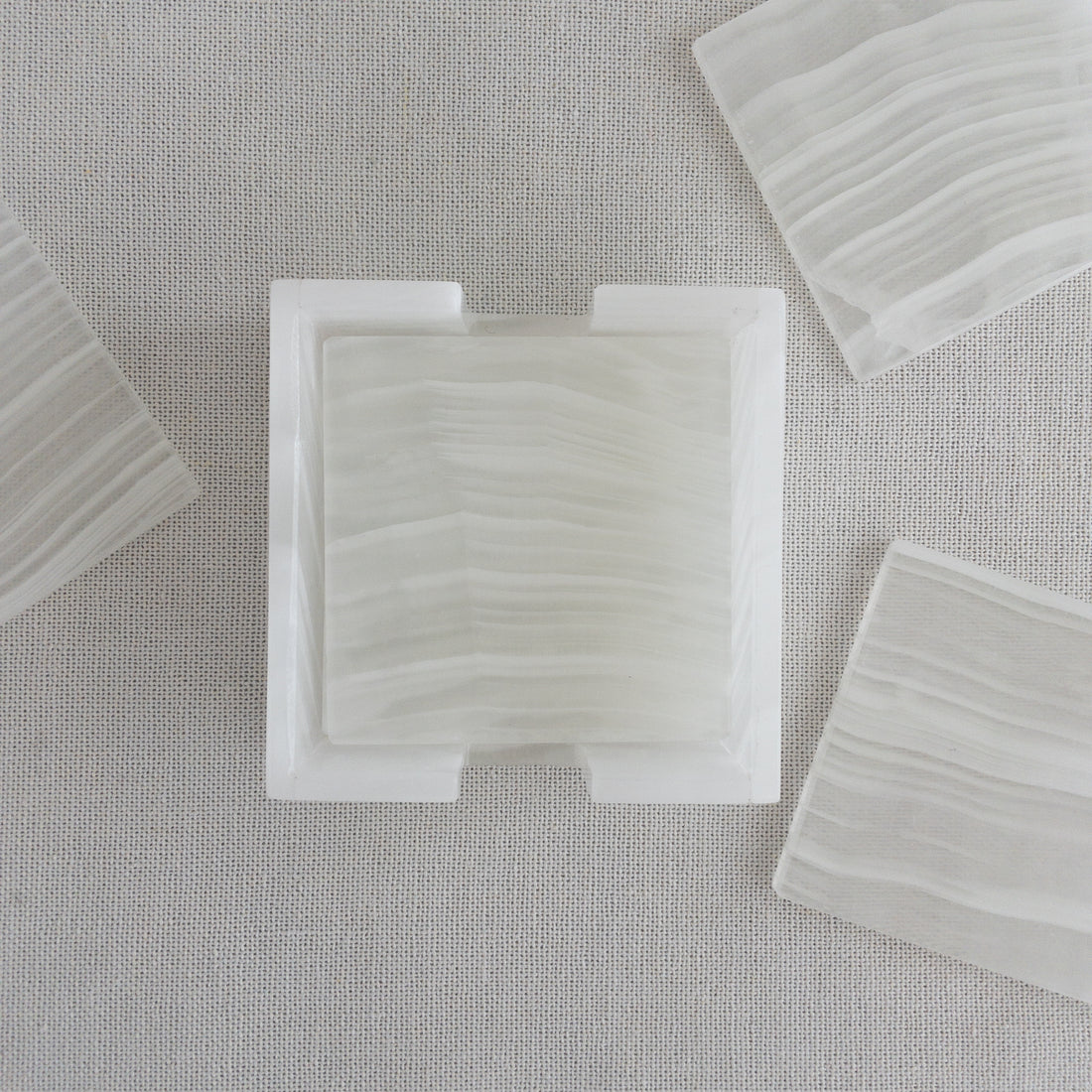 natural stone coasters on side table with glass of water