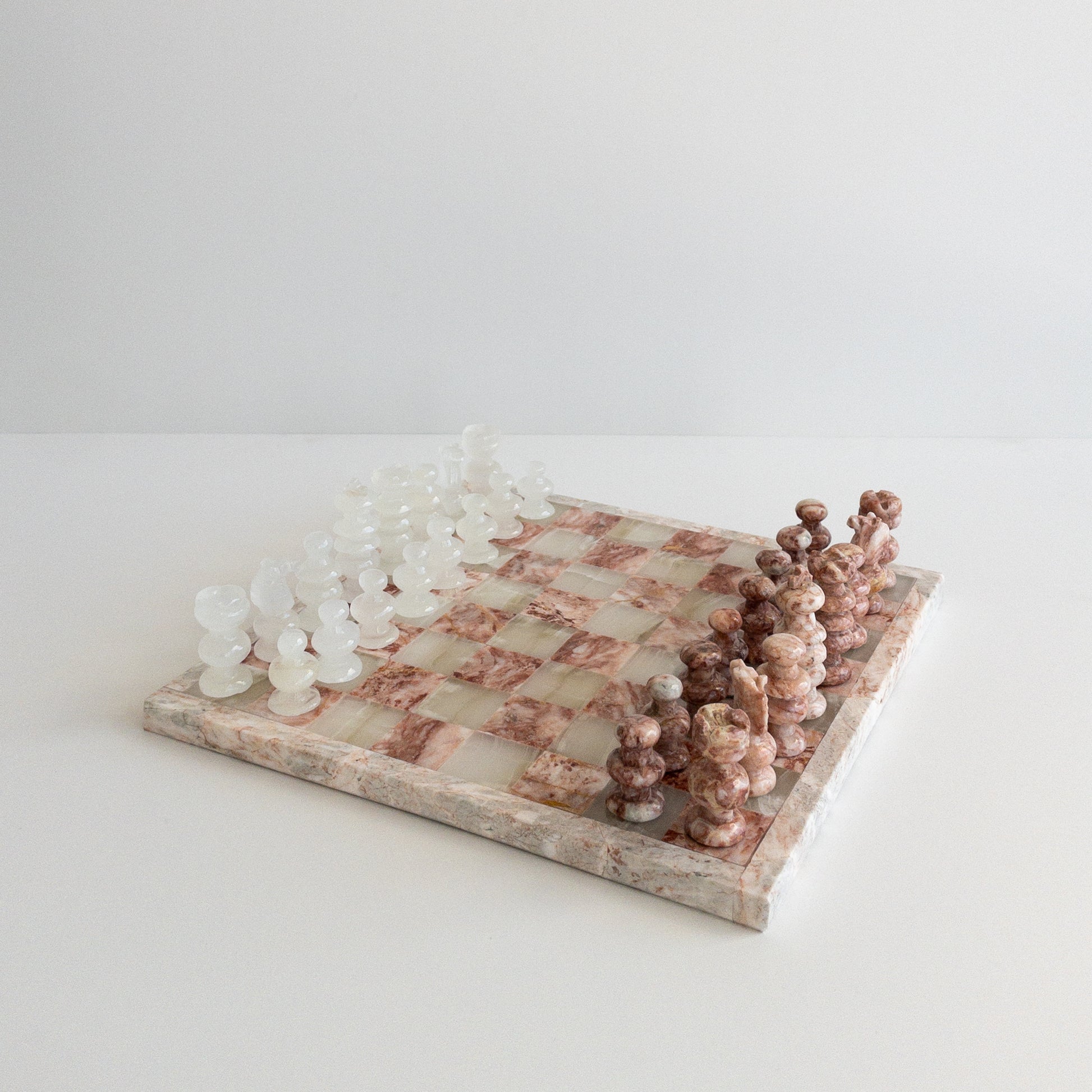 close-up of pink marble chess pieces with natural veining