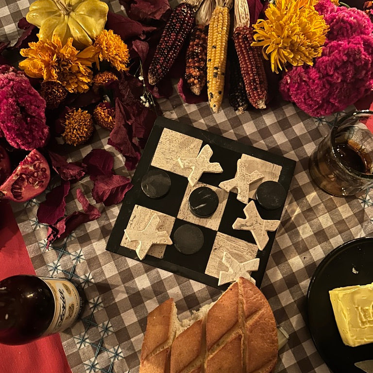 stone tic tac toe game on dinner table