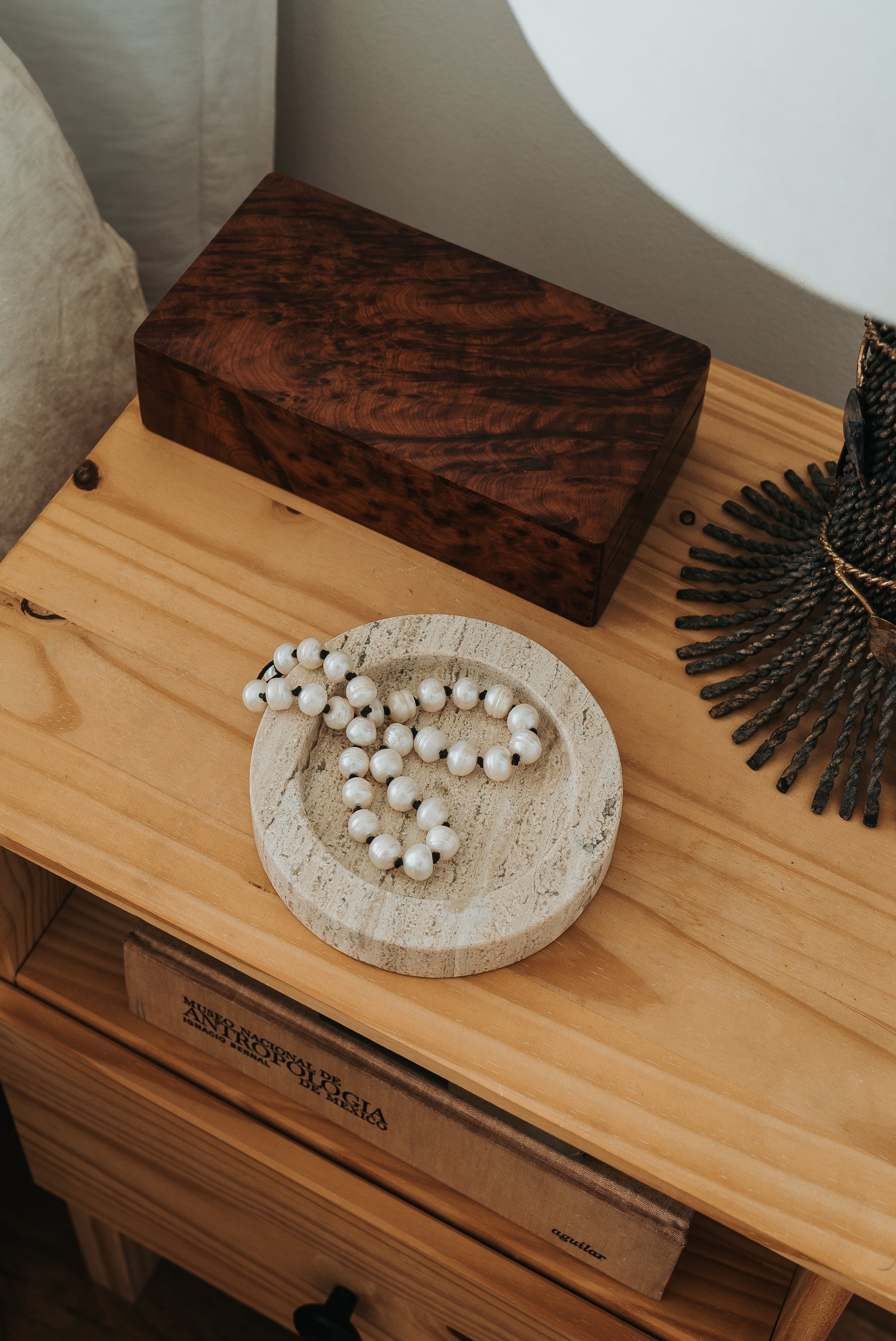 travertine stone jewelry tray on bedside table